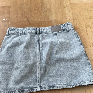 Grå jeanskjol med pärlor från ZARA - Säljer en snygg grå jeanskjol från ZARA med pärldetaljer framtill. Kjolen är endast använd några gånger men en gammal modell som jag inte tror finns längre🥰