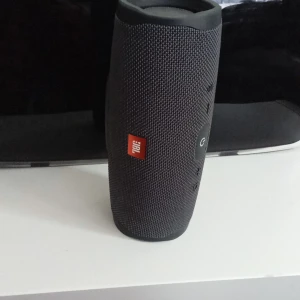 Den är vattentät ifall man vill ha den vid stranden - Det här är ingen bok, utan en bärbar högtalare från JBL. Perfekt för att ta med sig musiken överallt, med robust design och tydliga knappar för enkel användning. Passar dig som vill ha bra ljud på språng.