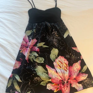 Svart vintage blommig klänning  - Ibiza vibes!!! Svart kort klänning i fint material!! Överdelen är väldigt stretchig så den passar en xs/större s!! Använd köp nu funktionen❤️
