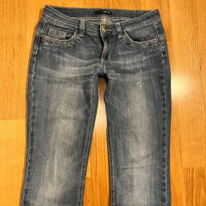 Lågmidjade Jeans - Supersnygga lågmidjade jeans i bra skick! Inga defekter utöver slitage vid bensluten💓 Tyvärr för små för mig och för långa!😇 De är en straight fit som faller snyggt över skon!💓 38,5cm rakt över midjan, 19cm grenhöjd, ca 86,5cm innerben och 18cm rakt över benöppningen!💓