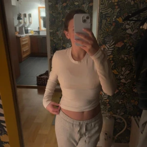 Vit croppad långärmad tröja från Gina Tricot -  enkel och stilren vit, lite croppad långärmad tröja från Gina Tricot. Figur sittande, använd fåtal gånger. Bekvämt och stretchigt material! 