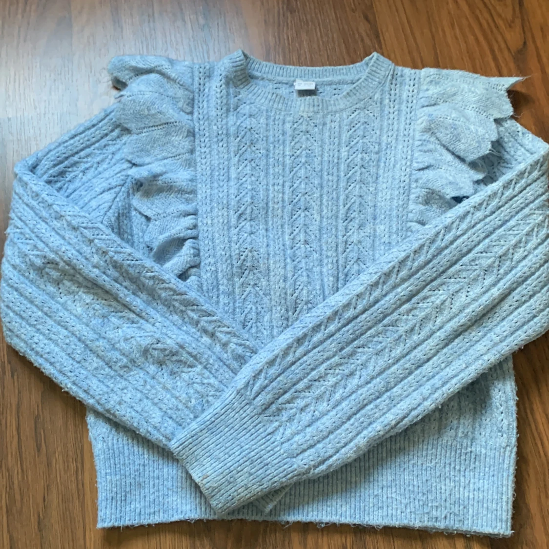 Ljusblå stickad tröja med volang från Lindex