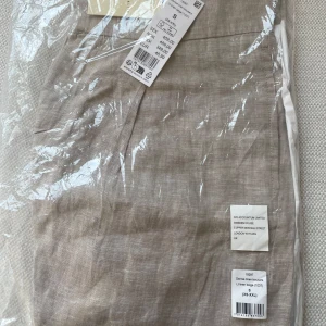 Oanvända Beige linnebyxor från Ginatricot - Oanvända inplastade med Prisetikett kvar. Säljer ett par stilrena beige linnebyxor från Ginatricot. Byxorna har en klassisk rak passform och är tillverkade i svalt linnematerial, perfekta för varmare dagar. De har hög midja och diskreta sömmar för en clean look. Prisetikett kvar. Nypris 459 kr 