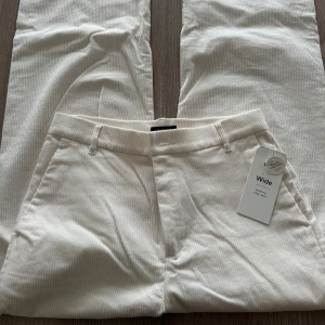 Vita vida byxor i manchester - Säljer ett par vita vida byxor i manchester med diskreta ränder. Byxorna har hällor för bälte och sidofickor. Perfekta för dig som gillar en avslappnad och trendig stil, de är också helt nya och oanvända , säljer de eftersom de är för stora.