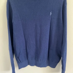   Ralph Lauren kashmir tröja - Säljer en Kashmir och ull blandnings tröja från Polo Ralph Lauren med rund halsringning och broderad logga på bröstet. Passar perfekt till allt. Jätte bra skick utan några skador. Skriv för mer frågor och funderingar!