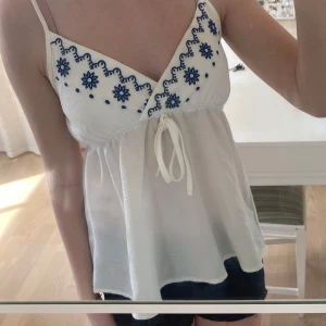 Broderad blus - Vid blus med blåa broderade detaljer, perfekt för vår och sommar🤍🩵