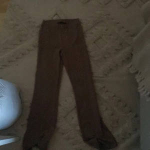 Bruna leggings från 157 - Säljer ett par bruna leggings från 157 i storlek M. De är stretchiga och har en tight passform. Med en slit vid benet 