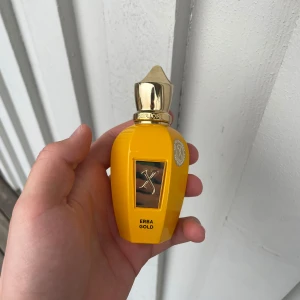 Erba Gold parfym från Xerjoff - Lyxig parfymflaska i klargul färg med guldfärgat lock och detaljer. Flaskan har en elegant, rundad form och en metallplatta framtill med Xerjoff-loggan. Märket och doftnamnet 'Erba Gold' syns tydligt på flaskan. Hör av dig vid frågor, alla boxar man får med finns kvar. Har köpt den från deloox har bevis om man vill se de.säljer den för jag behöver pengarna. Den är såklart äkta. Det är typ 48 ml kvar. Priset är ej hugget i sten