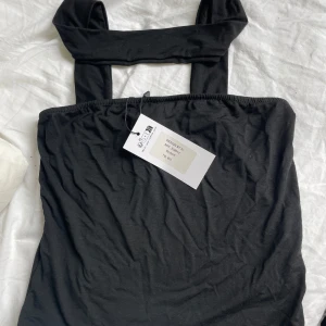 Svart tubtopp med breda band - Säljer en svart tubtopp från Design By Si med breda band, banden går runt nacken. Skicka ett meddelande till mig privat om ni vill ha bild på hur den sitter på 💕Toppen är enkel och stilren, perfekt att matcha med jeans eller kjol. Mjukt material och stretchig passform. Aldrig använd