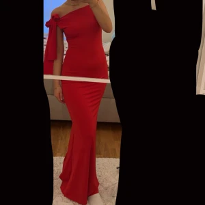 Röd balklänning  - Elegant röd oneshoulder långklänning med en band på ena axeln där man kan välja hur man själv vill knyta. Storlek xs/s, oanvänd. Köpte den på Plick men har nu hittat en annan klänning🫶🏻