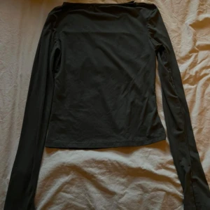 Svart och vit långärmad topp - Två stilrena långärmade toppar i svart och vitt. Båda har en enkel, rak passform och är tillverkade i ett mjukt, stretchigt material som känns skönt mot huden. Perfekta att matcha med jeans eller kjol för en clean look.