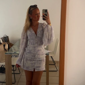 Lila Adoore klänning  - Superfin kort klänning (florence) från adoore. ljuslila och vitt med v-ringning, ballongärmar och knappar framtill. Sitter tajt i midjan och har ett lätt mönster. en är extremt eftertraktad o svår o få tag i. Säljer då jag köpt den långa modellen istället. Världens snyggaste klänning💜