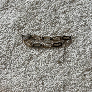 Chunky länkarmband i guld och svart - Snyggt armband med stora, rektangulära länkar i guld och svart. Justerbar kedja för perfekt passform. Perfekt accessoar för att lyfta din outfit med en cool och trendig vibe. OBS!!! KOMMER GÖRAS RENT INNAN SICKAD