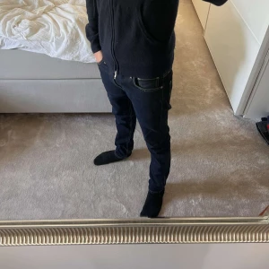Levi's jeans - Säljer ett par Levi's 512 jeans i mörkblå denim. Modellen har smal passform med raka ben och klassiska kontrastsömmar. Snyggt tidlöst snitt och fem fickor. Perfekta om du gillar en clean och stilren look. Personen på bilden är 177! Köpta för 1150kr!
