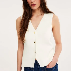 Topp - Stickad väst topp med guld knappar, från KappAhl. I nyskick med lappen kvar, nypris -399kr.