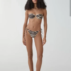 Zebramönstrad bikiniunderdel från Mango - Snygg bikiniunderdel från Mango med zebramönster i svart och beige. Helt oanvänd och inte prövad. Säljer då den ej hann komma i tid och kunde ej skicka tillbaka. Storlek S