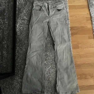 Grå low waist bootcut jeans med fem fickor - Snygga grå jeans med bootcut passform och klassisk femficksdesign från lager 157. Jeansen är lowboot som är låg midja och raka ben som blir vidare nedtill i storlek S. Tillverkade i mjukt jeanstyg, perfekta för en avslappnad och trendig look. Använda 1 gång
