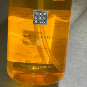 Ny! Rituals The Ritual of Mehr Home Perfume - Helt ny! Fräsch hemparfym från Rituals i serien The Ritual of Mehr. Kommer i en genomskinlig orange plastflaska med svart spraymunstycke. Doften är en energigivande mix av söt apelsin och cederträ. Perfekt för att boosta känslan hemma. Sälja numera online.