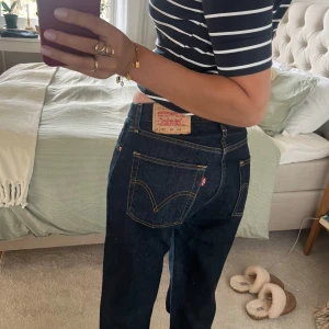 Levi's 751 mörkblå jeans W31 L34 - Mörkblå Levi's 751 jeans med klassisk femficksdesign och snygga kontrastsömmar. Jeansen har rak passform och normal midja, tillverkade i robust denim. Perfekta för dig som gillar en tidlös och clean look. Avklippta längst ner men är ändå långa på mig som är 175cm!