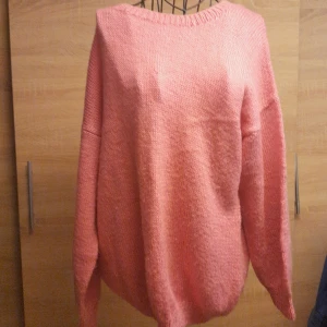 Oversized rosa stickad tröja - Mysig oversized stickad tröja i en härlig rosa färg. Tröjan har rund halsringning och långa ärmar med avslappnad passform. Perfekt för lager på lager och chill dagar. Enkel design utan mönster eller detaljer.