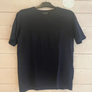 Mörkblå t-shirt från Jack & Jones XS - En basic mörkblå t-shirt från Jack & Jones Essentials i ekologisk bomull. Klassisk rund halsringning och korta ärmar, perfekt för en clean och enkel stil. Passar dig som gillar minimalistiska plagg och vill ha något som funkar till allt. Har två av denna så 100kr st 