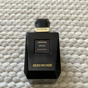 Keiko Mecheri Savile Eau de Parfum 75ml - Lyxig parfym från Keiko Mecheri, Savile Eau de Parfum i en elegant svart glasflaska med guldiga detaljer. Flaskan rymmer 75ml men har ca 50 ml i sig och har en geometrisk, exklusiv design. Tillverkad i Frankrike och passar dig som gillar unika dofter. (Denna parfym går inte längre och köpa)
