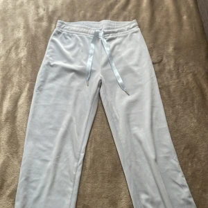 Ljusblå mjukisbyxor från Gina Tricot - Supermjuka ljusblå flared sametsbyxor från Gina Tricot med silke snörning i midjan. Perfekta för chill dagar och har en riktigt skön känsla mot huden. Snygg och enkel design som passar till allt OBS helt oanvända och inte skavda i benen.