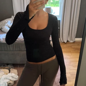 Svart långärmad topp  - Svart långärmad topp från Gina Tricot med snygg, djup rundad urringning. Tight passform och stretchigt material☺️Använd sparsamt, inga defekter!🥰 Passar till allt!!
