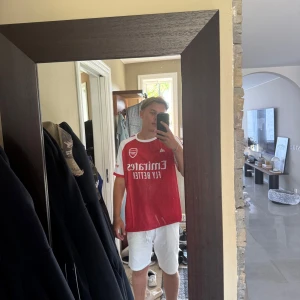 Arsenal röd matchtröja Adidas XL - Säljer en Arsenal fotbollströja i rött med vita detaljer och klubbmärke på bröstet. Köpt utomlands men kvaliten och materialet är 10/10, helt oanvänd ! 