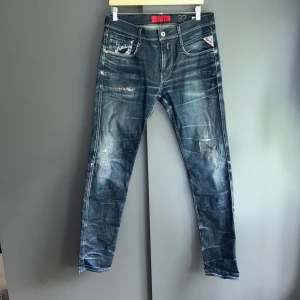 Replay anbass selvedge jeans med slitningar - - Fint skick, några defekter, lagning i skrevet som inte syns och sedan är en av slitningarna genomskådbara. Nypris ca 2000kr. Storlek W32 L34, passar dig som är mellan 175-188cm ungefär. Mått finns på sista bilderna. Skriv för mer information!🤝 