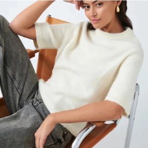 Vit stickad tröja med kort ärm - Supermjuk vit stickad tshirt, endast använd en gång - mycket bra skick!🩷. Perfekt för lager-på-lager och ger en clean, stilren vibe. Stl XS men stor i storleken, tycker att den sitter som en S!