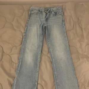 Ljusblå raka jeans från Zara - Säljer ett par ljusblå jeans från Zara i storlek 152. Jeansen har klassisk femficksdesign, raka ben och normal passform. Tillverkade i bomull med snyggt tvättad look och subtila slitningar på låren. Perfekta till sneakers eller boots.
