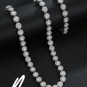 Silverfärgat halsband och armband med glittriga stenar - Säljer ett matchande set med halsband och armband i silverfärg, båda dekorerade med runda, glittriga stenar. Perfekt för att ge en extra touch till din outfit. Säljs tillsammans. Halsbandet är 45cm o armbandet 18cm, helt oanvänt!