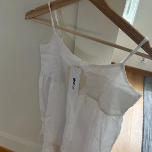 Vit somrig klänning från Gina Tricot - Säljer en söt vit klänning från Gina Tricot med tunna axelband. Perfekt för varma dagar och enkel att styla med sandaler eller sneakers. Klänningen är helt ny. 🥰🥰