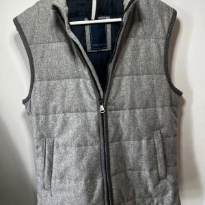 Grå Berkeley väst - Snygg grå quiltad väst från Berkeley i samarbete med Vitale Barberis Canonico. Tillverkad i italiensk ullflanell och helfodrad. Skick 10/10 som ny, passar Medium. Nypris 2500 säljer för 1200kr.