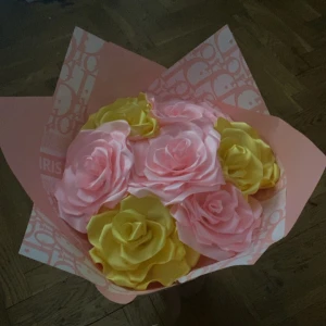 Bukett med konstgjorda rosor i satin - Säljer en bukett med konstgjorda rosor i satinmaterial. Rosorna är i två färger: ljusrosa och gul. Blommorna är stora och har en glansig yta som ger ett lyxigt intryck. Perfekt som dekoration eller present.