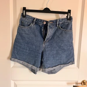 Blå jeansshorts från ONLY - Säljer ett par klassiska blå jeansshorts från ONLY i storlek XS. Modellen har normal passform och uppvikta benslut. Perfekta till sommaren och lätta att matcha med olika toppar.