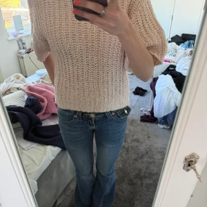 Ljusrosa stickad tröja med kort ärm - Säljer en ljusrosa stickad tröja med korta ärmar och rund hals. Tröjan har en grovstickad struktur och är lite boxig i modellen, perfekt att styla med jeans eller kjol. Sval och skön till sommaren.