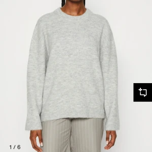 Ljusgrå stickad tröja - Säljer en enkel och stilren ljusgrå stickad tröja med rund halsringning. Tröjan har lång ärm och en avslappnad passform, perfekt för lager-på-lager under kyliga dagar. Storlek S