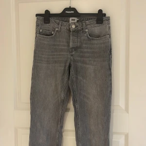 Grå jeans - Grå jeansbyxor från lager med rak passform och råa, avklippta benslut. Klassisk femficksmodell med knapp och dragkedja i gylfen. Perfekta för en avslappnad och trendig look.