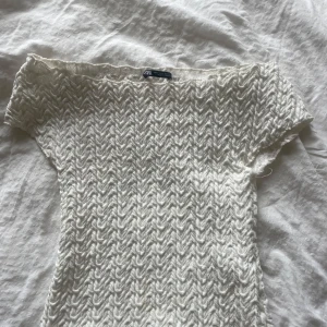 Vit topp från Zara - Säljer en vit topp från Zara med korta ärmar, of shoulder. Nästan aldrig använd. 