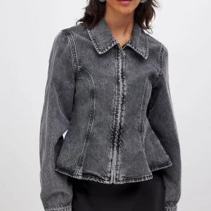 Söker !! - Söker en grå jeansjacka med markerade svarta sömmar och klassisk krage. Jackan har lång ärm och en figurnära passform som ger en snygg siluett. Perfekt att styla till både kjol och byxor.