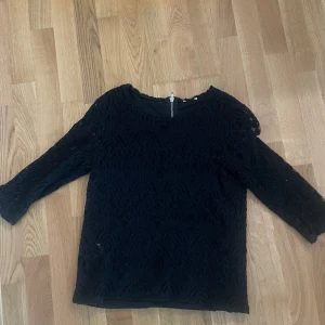 Svart spetsblus med trekvartsärm - Jag säljer en svart blus med spetsmönster och trekvartsärmar. Passar mig som har storlek xxs/xs/s. Blusen har rund halsringning och dragkedja bak. Säljer pga att den inte används längre💞