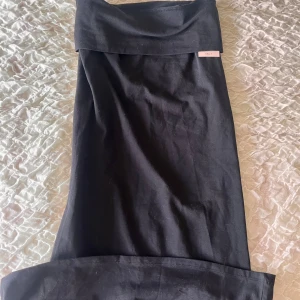 Svart lågmidjad långkjol  - En svart långkjol från Nelly med nedvikt kant upptill som ger en snygg och enkel look. Kjolen är aldrig använd och har lappen kvar 🫶🏻
