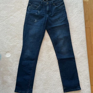 Jeans -Solid - Jeans från Solid i regular fit. Mörkblå med sliten look framtill. Midjan är midwaist, gylfen är dragkedja. Size W28, L32. Innerfickor (fram) är trasiga. 