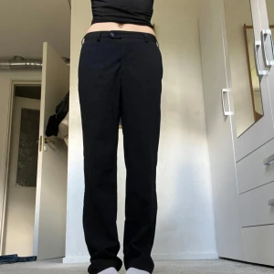 Svarta kostymbyxor med fickor  - Kostymbyxor med coola fickor! Innerbenslängd=81 och midjemått = 44 