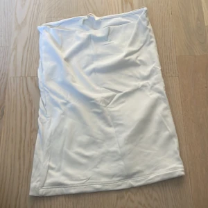 Vit tubkjol från H&M - Säljer en enkel och stilren vit tubkjol från H&M. Kjolen är kort och har en rak passform utan synliga detaljer. Perfekt att matcha med olika toppar för en clean look.
