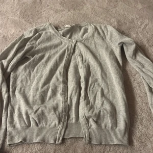 Ljusgrå kofta från H&M - Ljusgrå kofta från H&M Basic med rund halsringning och knappar framtill. Tröjan har långa ärmar och säljer den då den inte passar mig längre priset kan vi diskutera💗