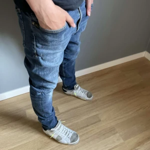 Blå jeansbyxor från Tiger of sweden - Klassiska blå jeansbyxor från tiger of sweden. Den har ett litet hål under men det är inget man ser eller märker pris är inte hugget i sten!! Han som står där är 170cm och väger ca 55-60.