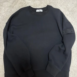 Svart sweatshirt från Stone Island -  En autentisk helsvart Stone island med helsvart badge. Bra kvalité på tröjan, storlek XXL men passar även XL.